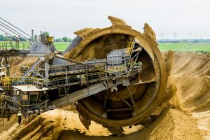 Round brown and grey metal heavy equipment on sand