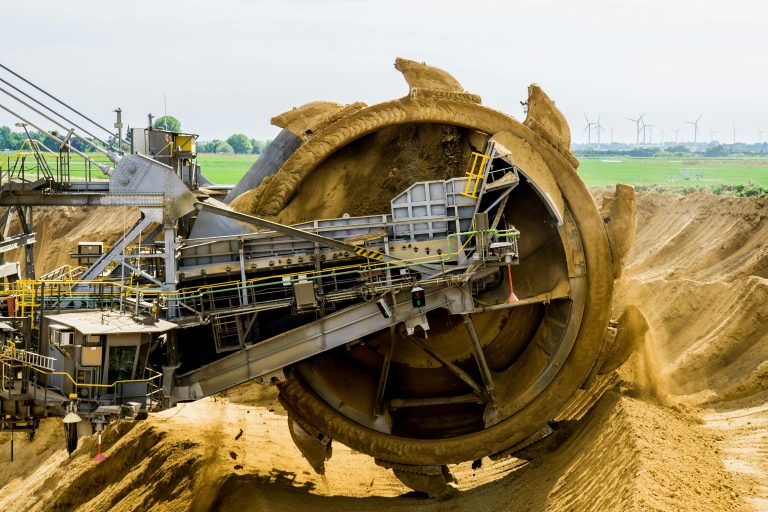 Round brown and grey metal heavy equipment on sand